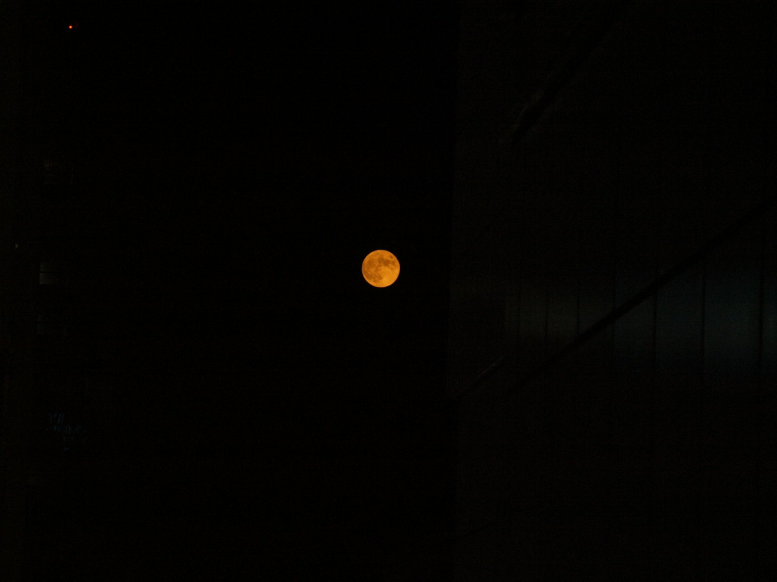 Bulan oranye di latar belakang gelap
