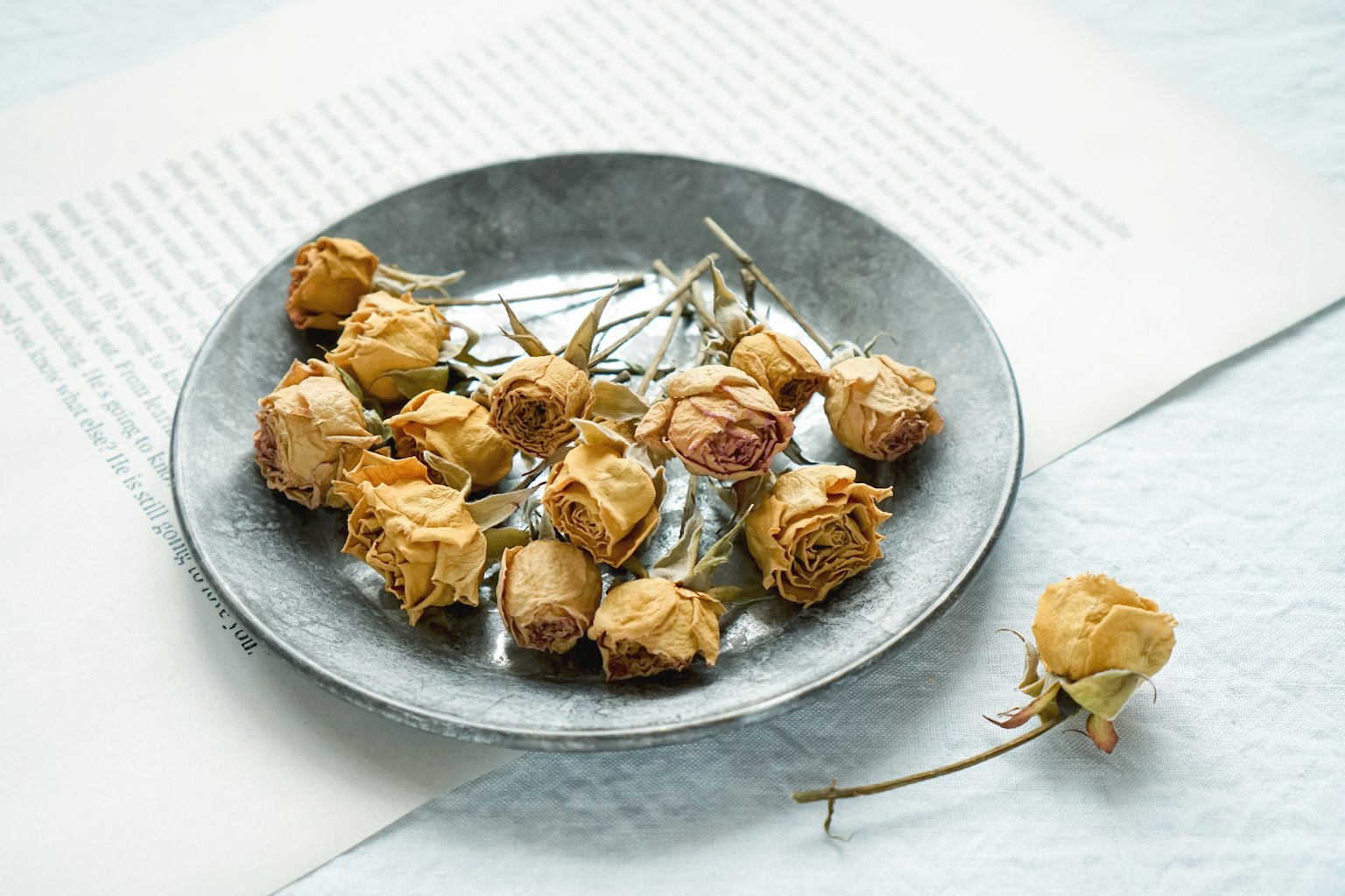 Roses séchées disposées sur une assiette en argent
