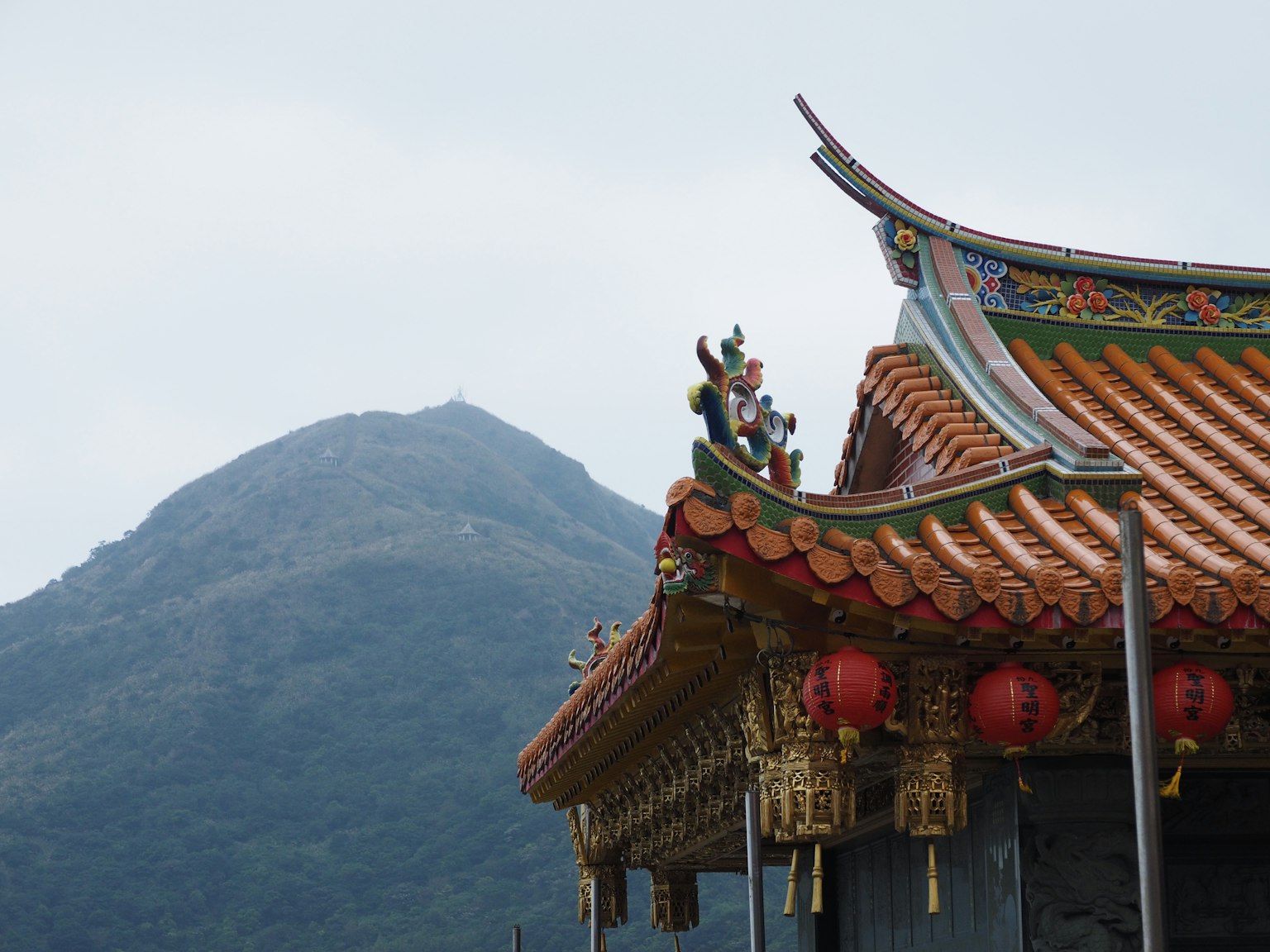 ทิวทัศน์ที่สวยงามของหลังคาที่มีการตกแต่งและภูเขาเป็นพื้นหลัง