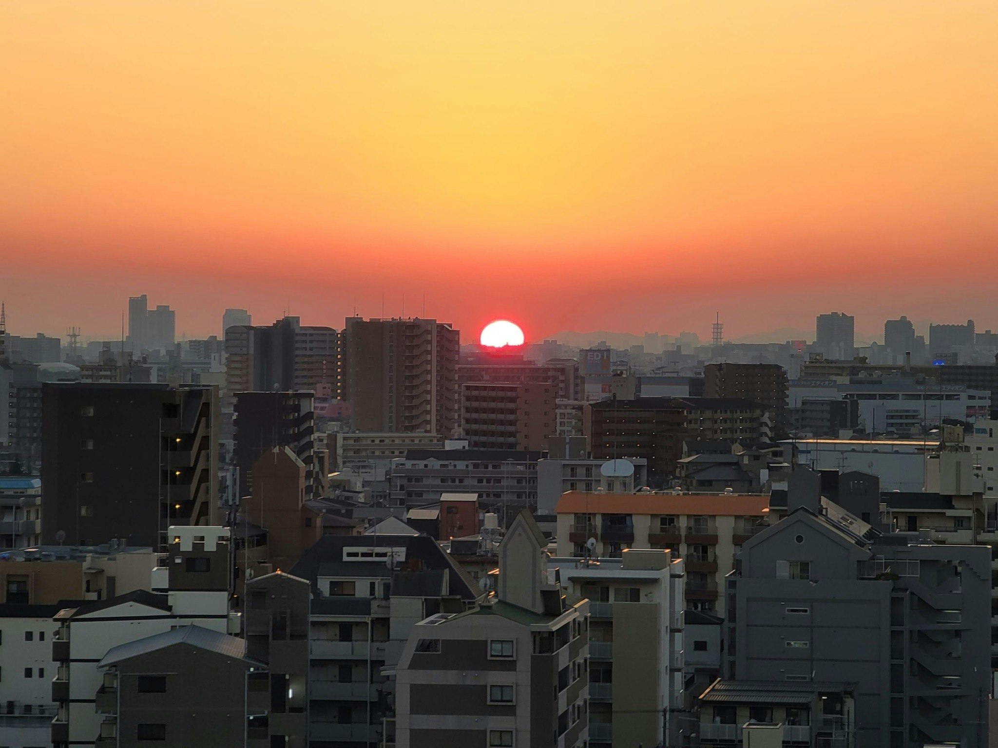 夕焼けの街並みと太陽が沈む都市のスカイライン