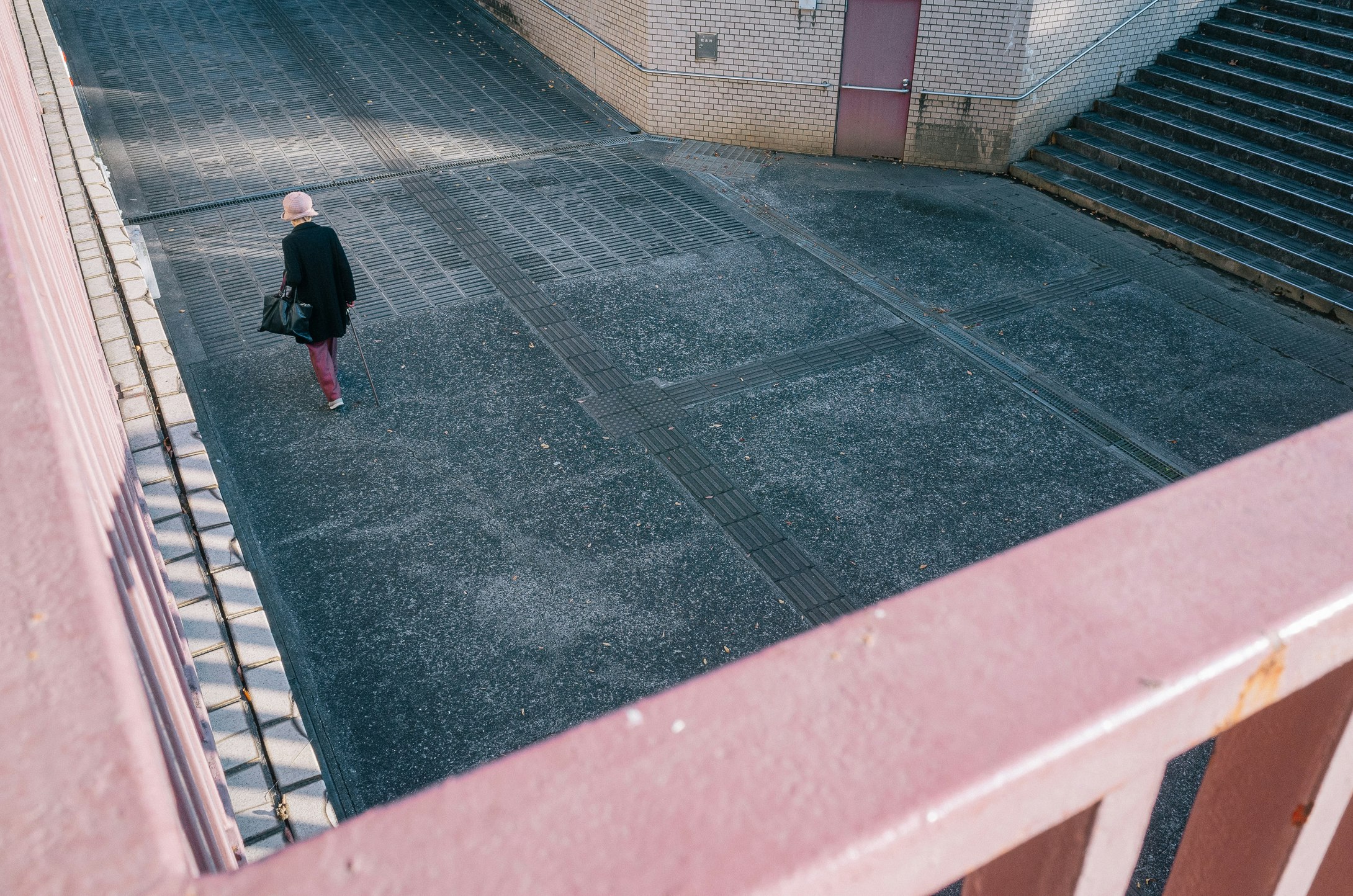 路地の坂道を歩く人物のある街角