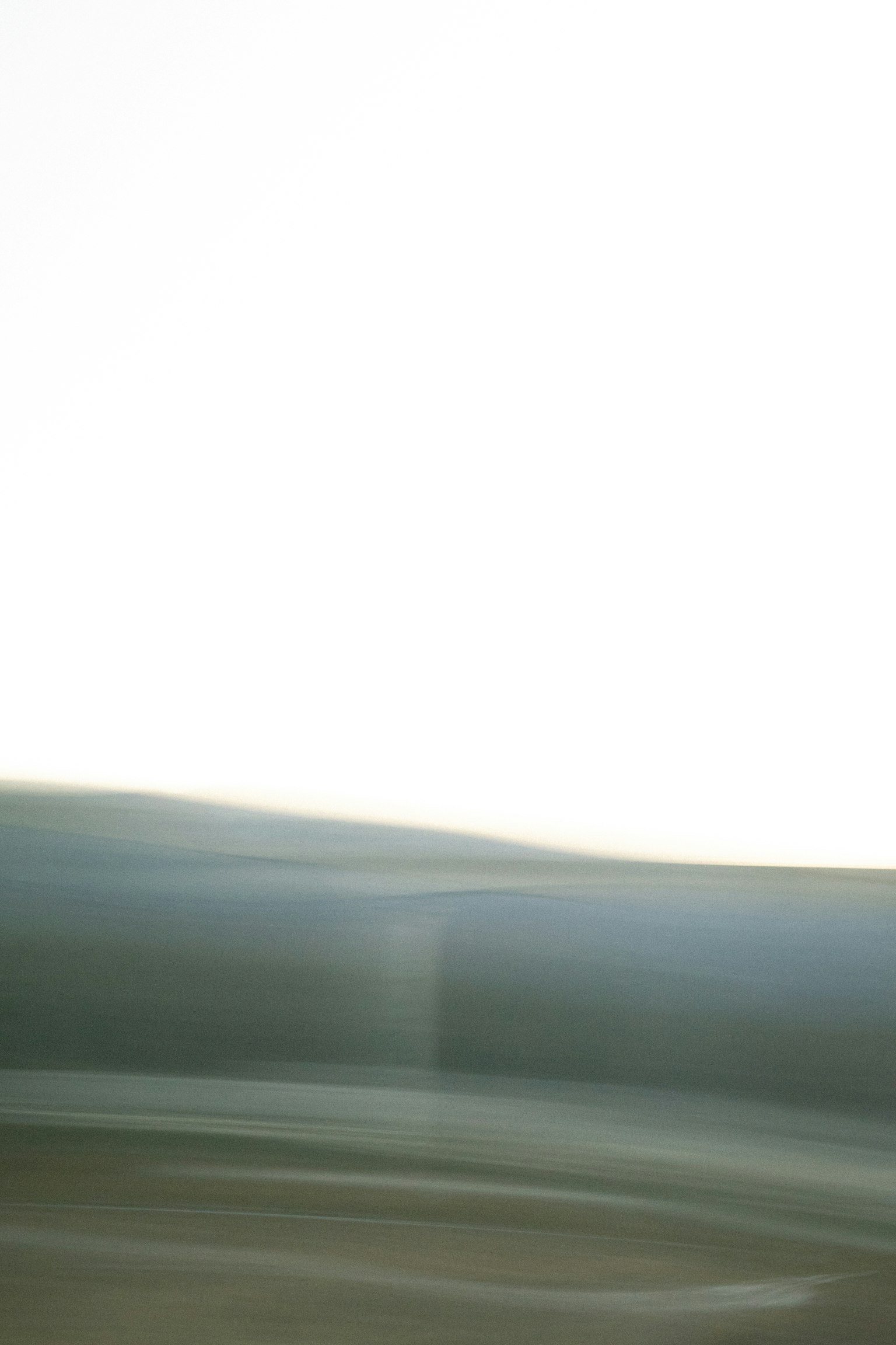 Blurred landscape featuring soft blue and white hues