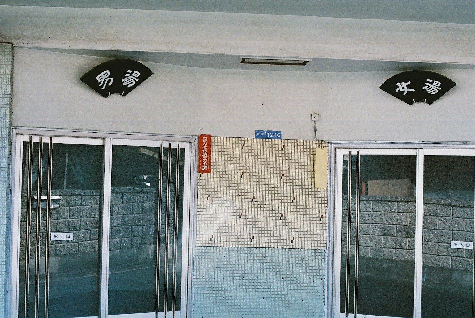 Pintu masuk gedung dengan dua papan dan pintu kaca