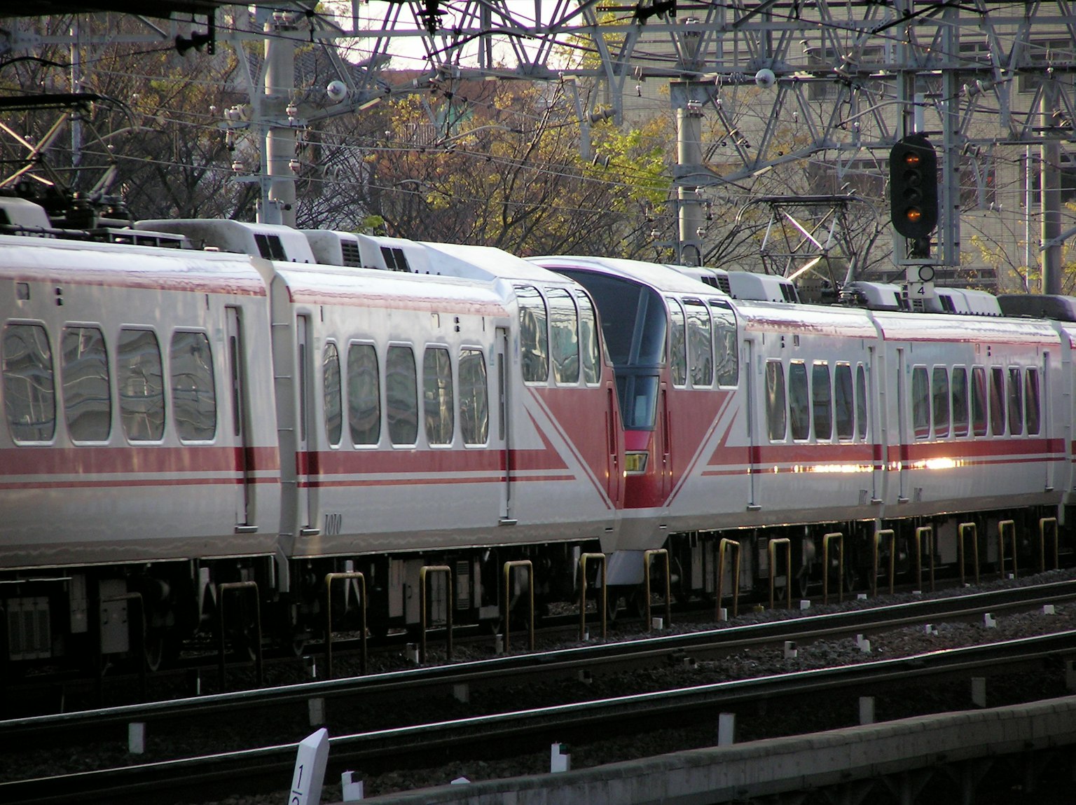 Treno con strisce rosse distintive che corre sui binari