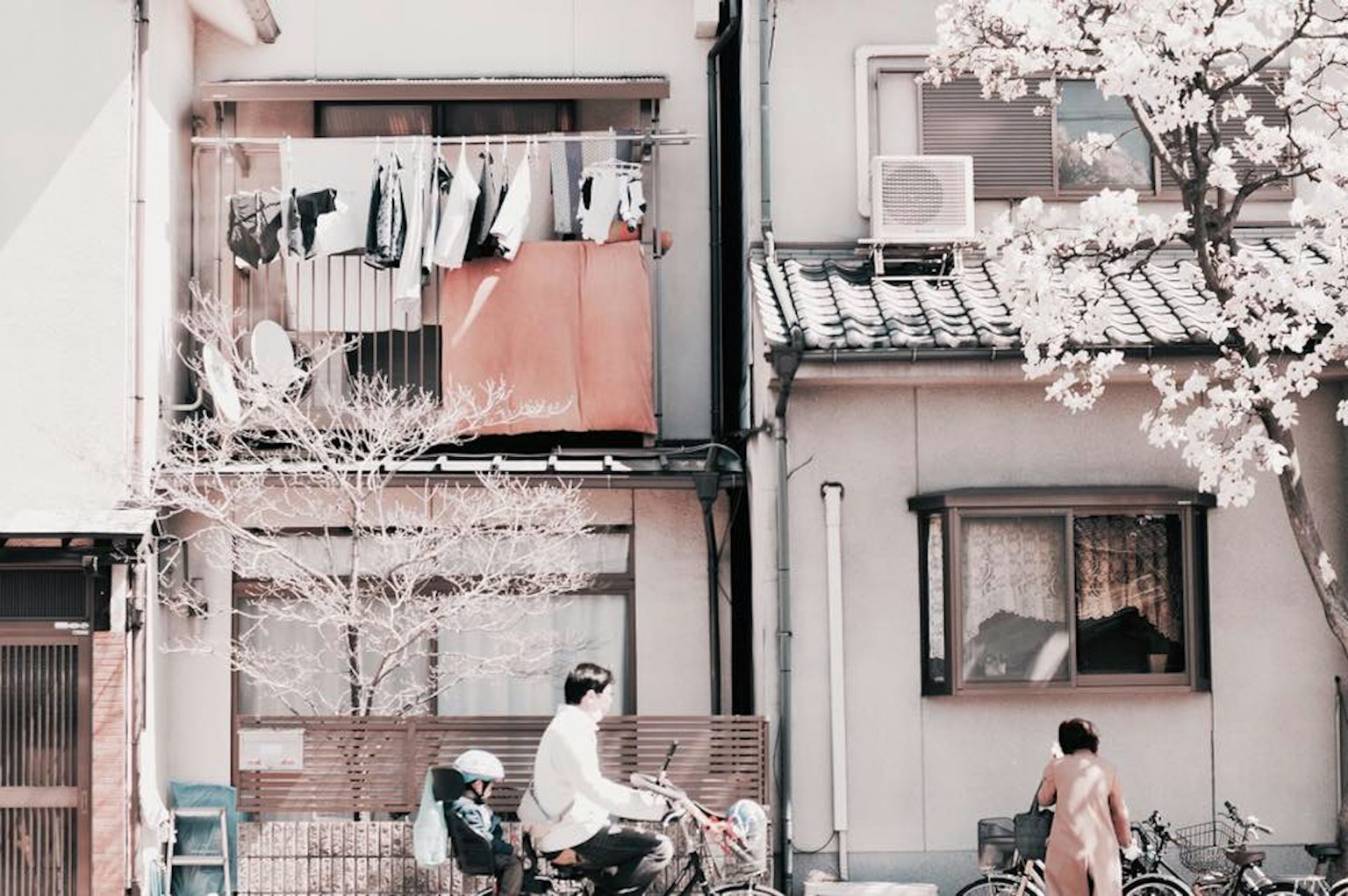 住宅街景，陽台上晾著衣服，騎自行車的人