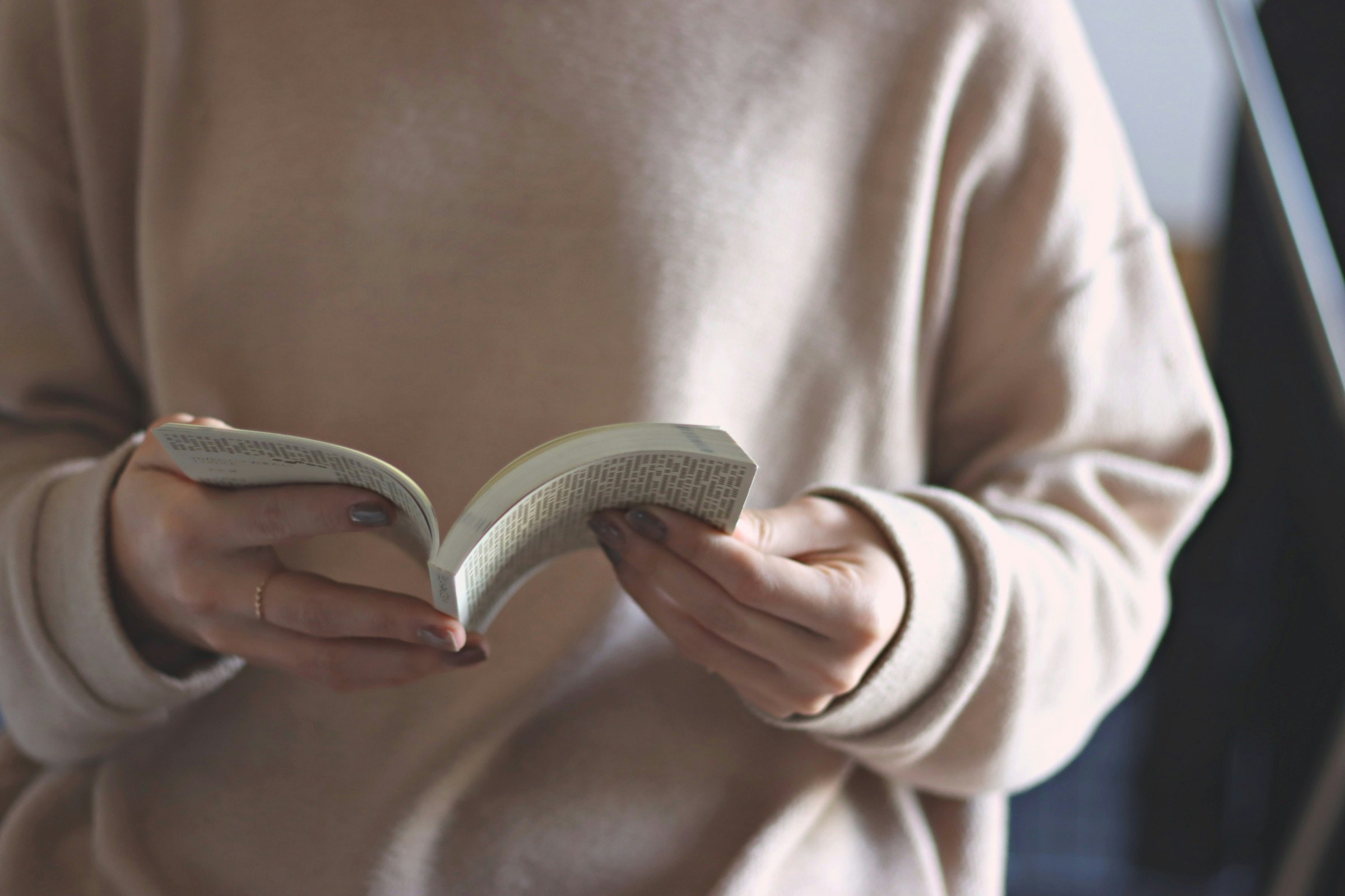 Nahaufnahme von Händen beim Lesen eines Buches