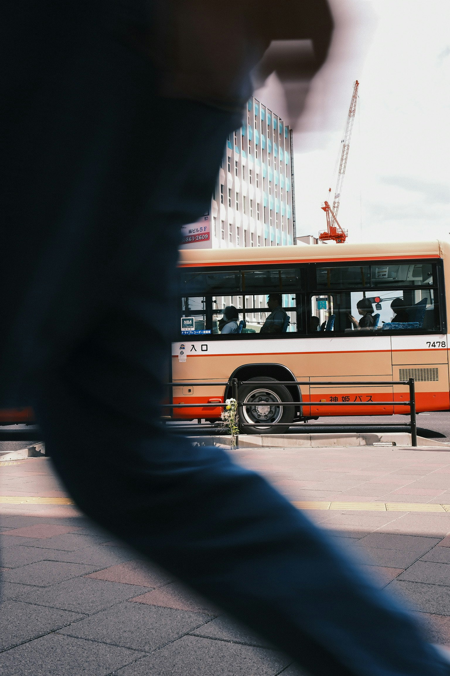 Una scena cittadina con un autobus che passa e un pedone sfocato