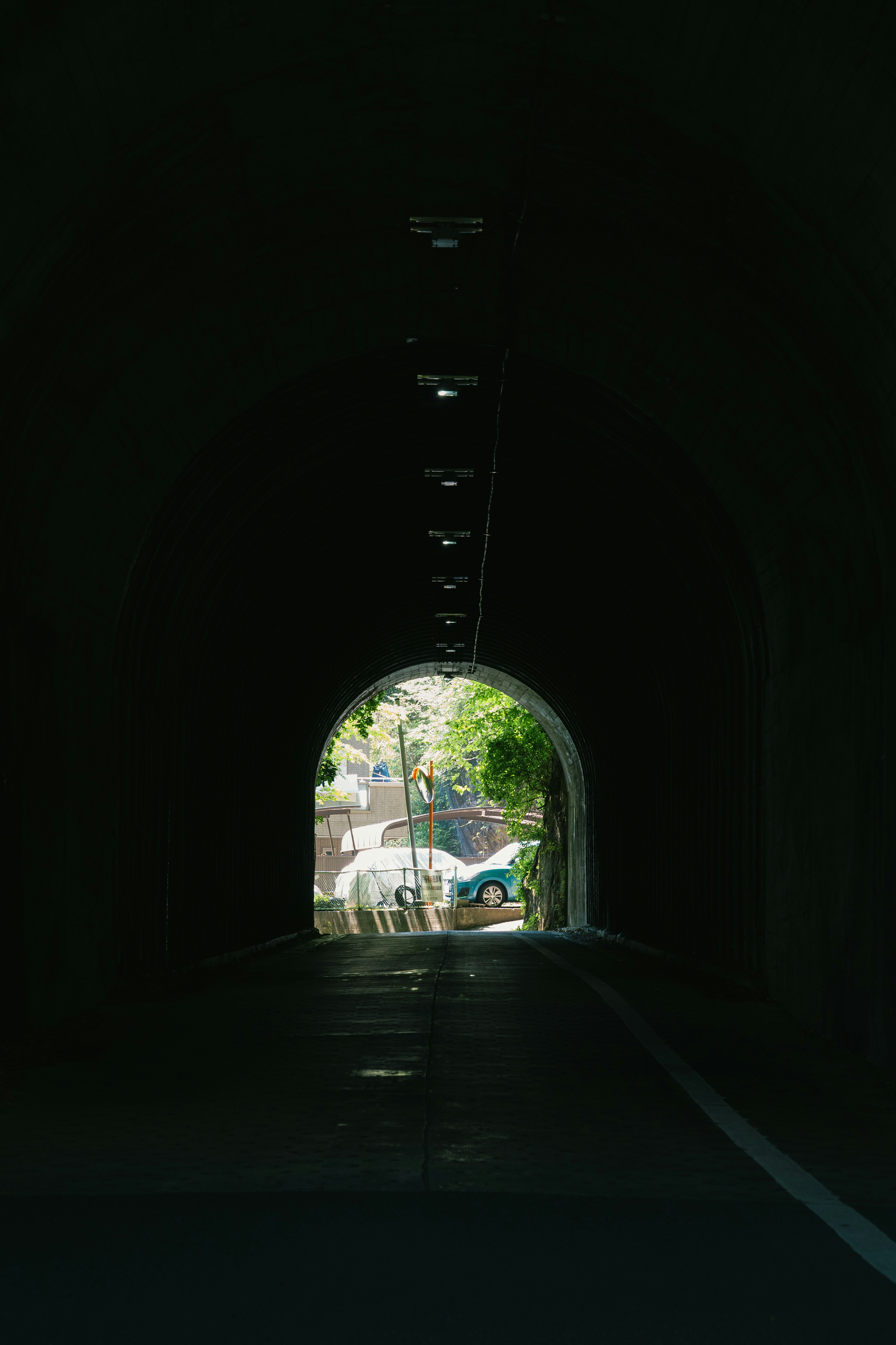 トンネルの中から見える車と緑の風景
