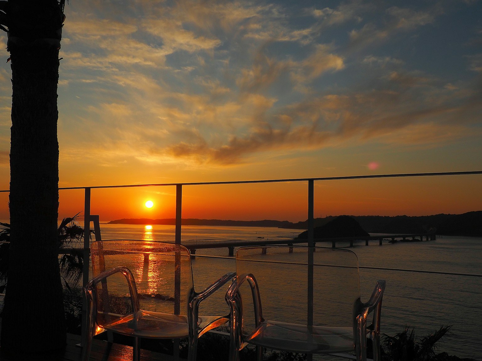 Magnifique coucher de soleil sur l'océan avec un pont et des chaises transparentes