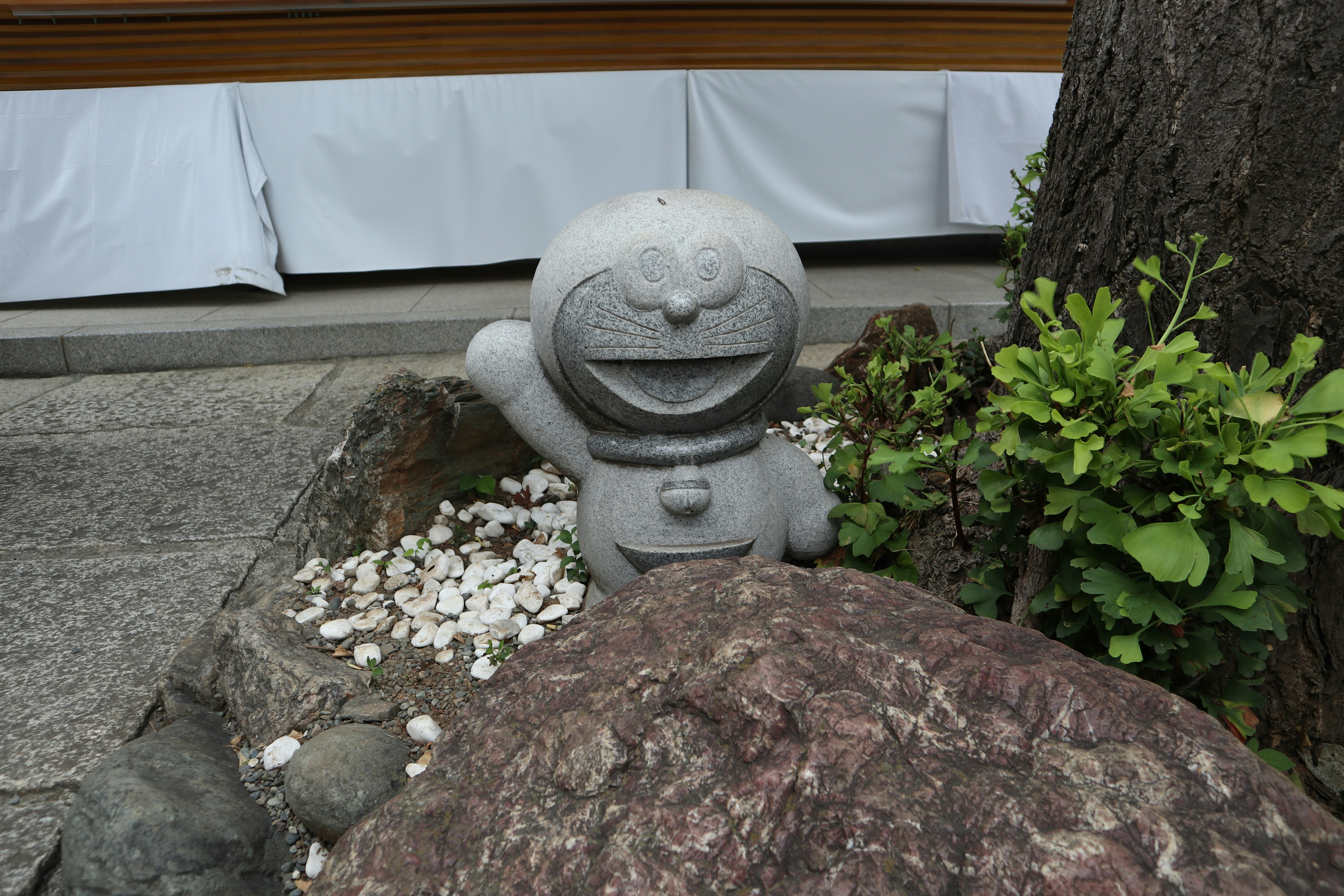 石の小さな置物と花のある庭の縁