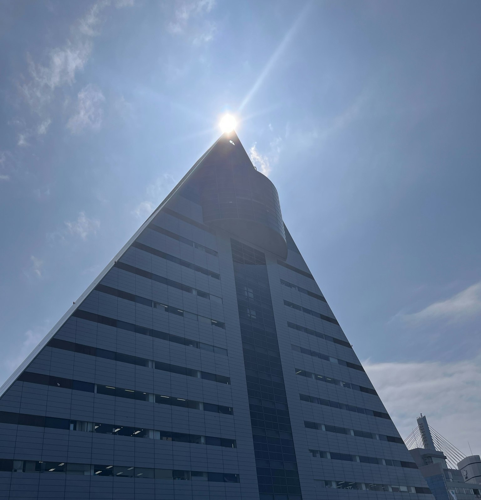 一座现代的金字塔形建筑在蓝天之下耸立