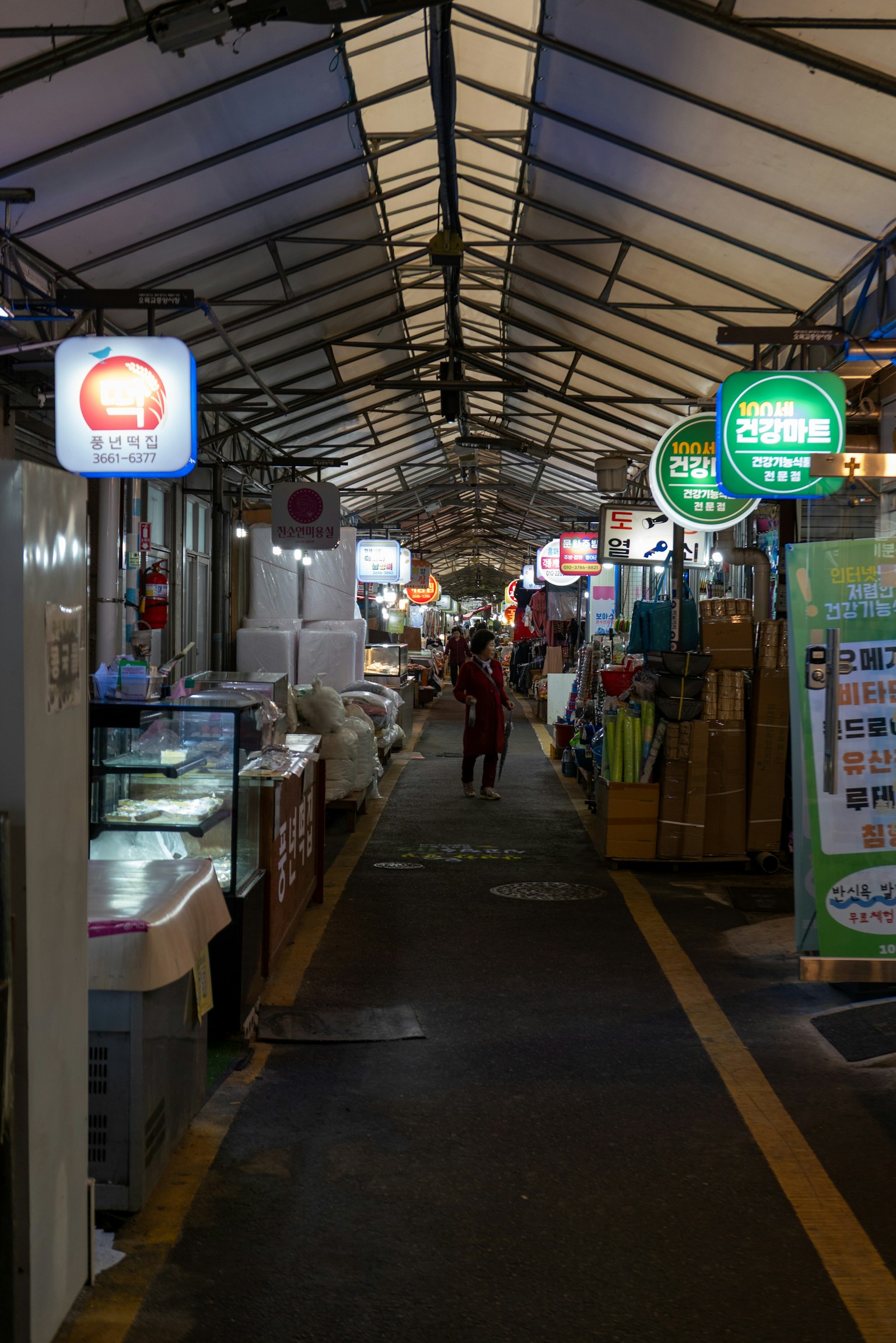 有顶市场走廊，食品摊位和霓虹灯标志