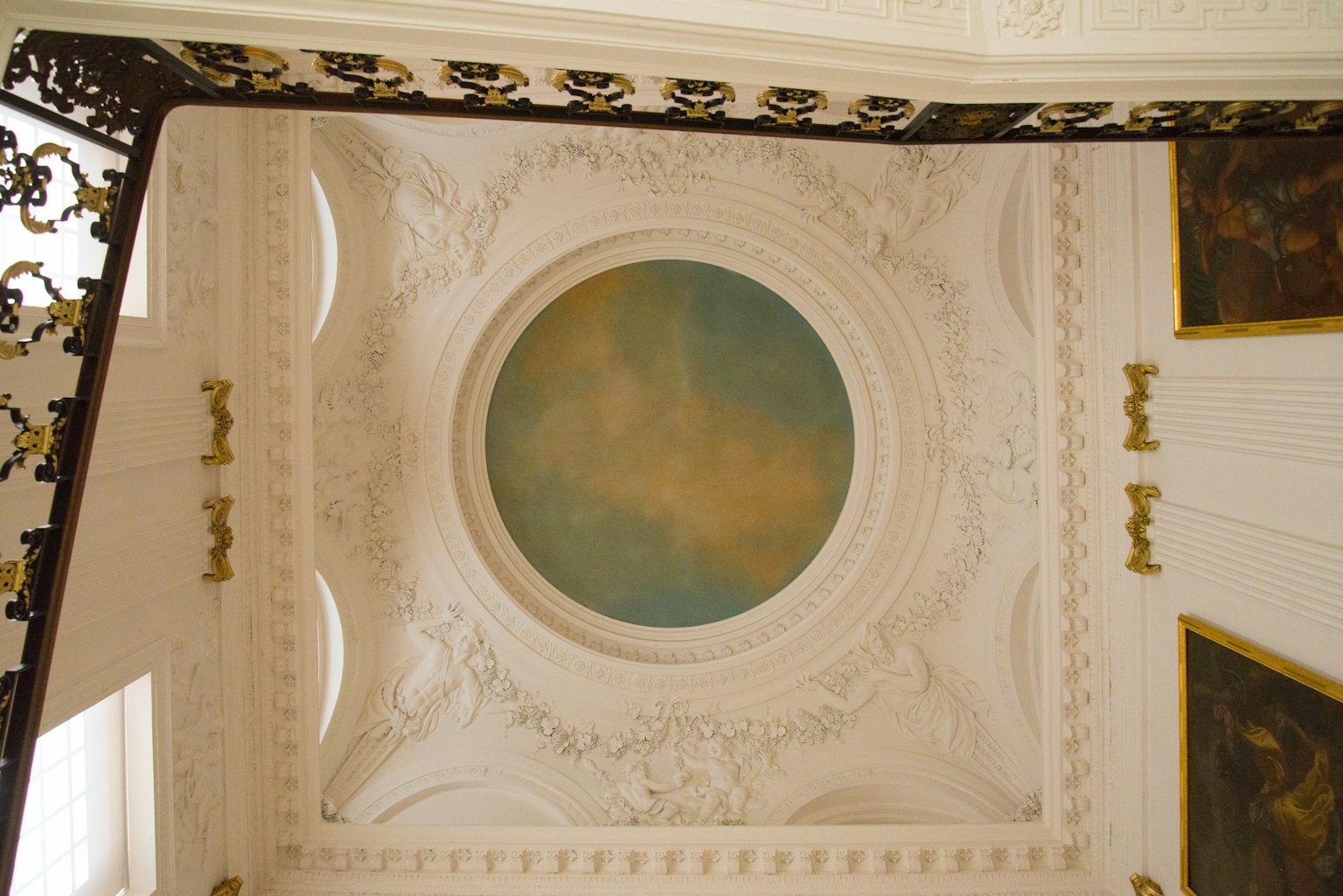 Plafond orné avec une peinture circulaire centrale en tons de bleu doux