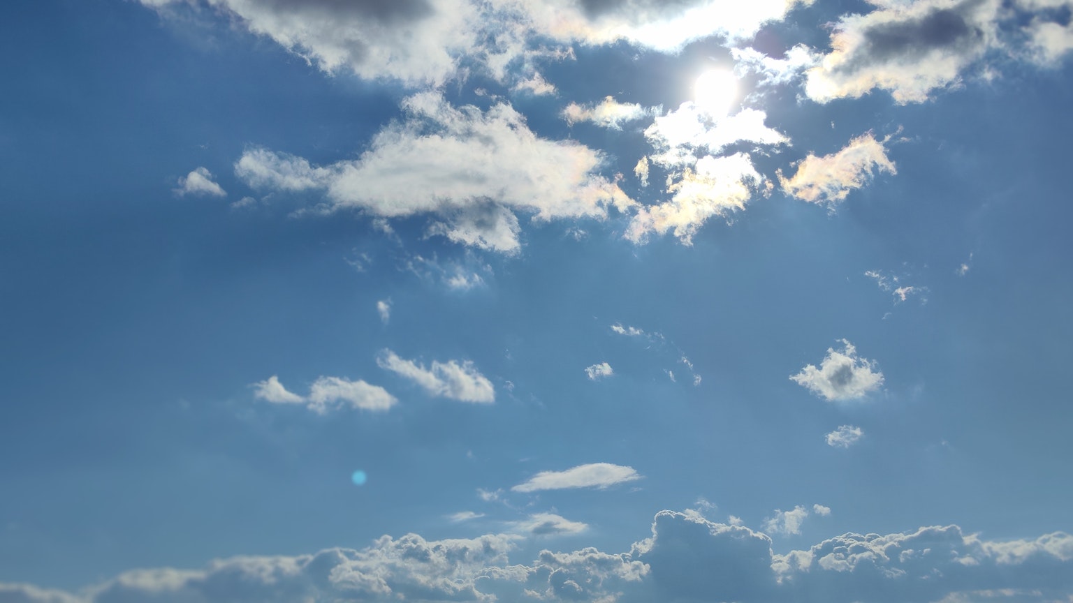 Cielo blu con nuvole e luce solare che filtra