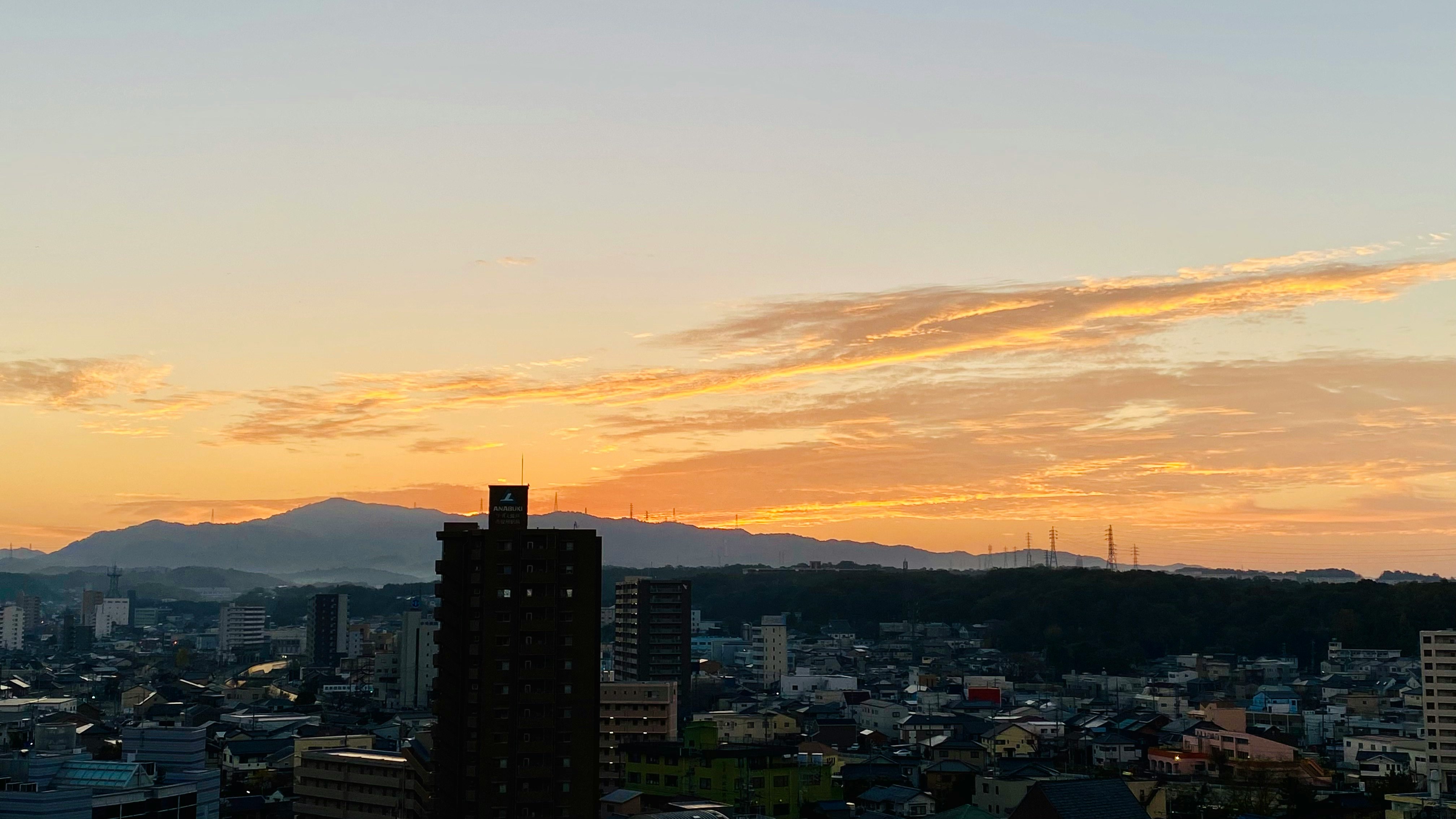 夕焼け空の下で広がる街並みと山の稜線