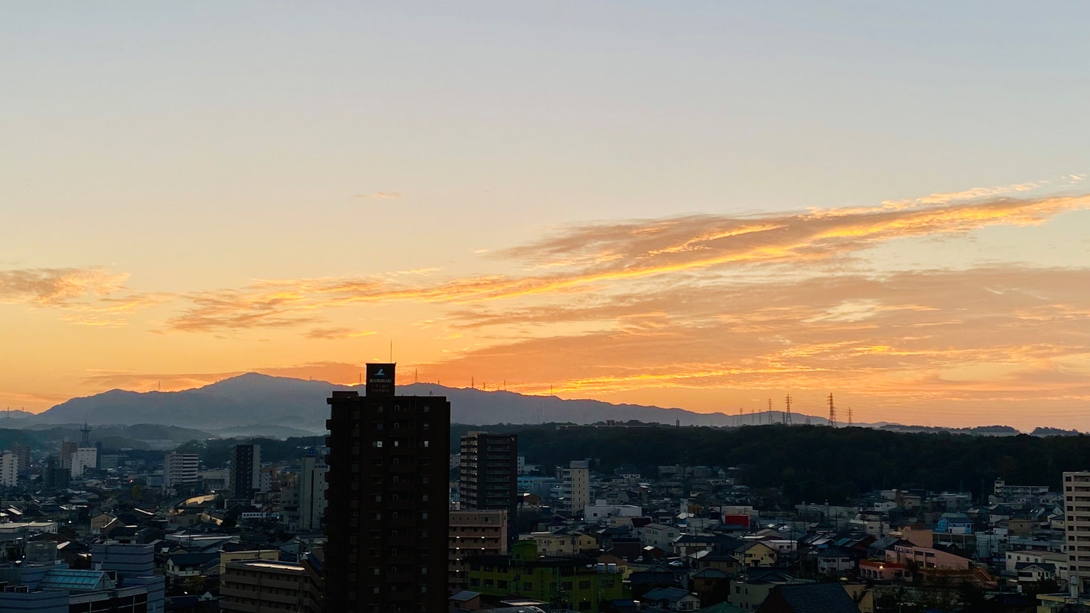 Ciel au coucher de soleil avec paysage urbain et montagnes en arrière-plan