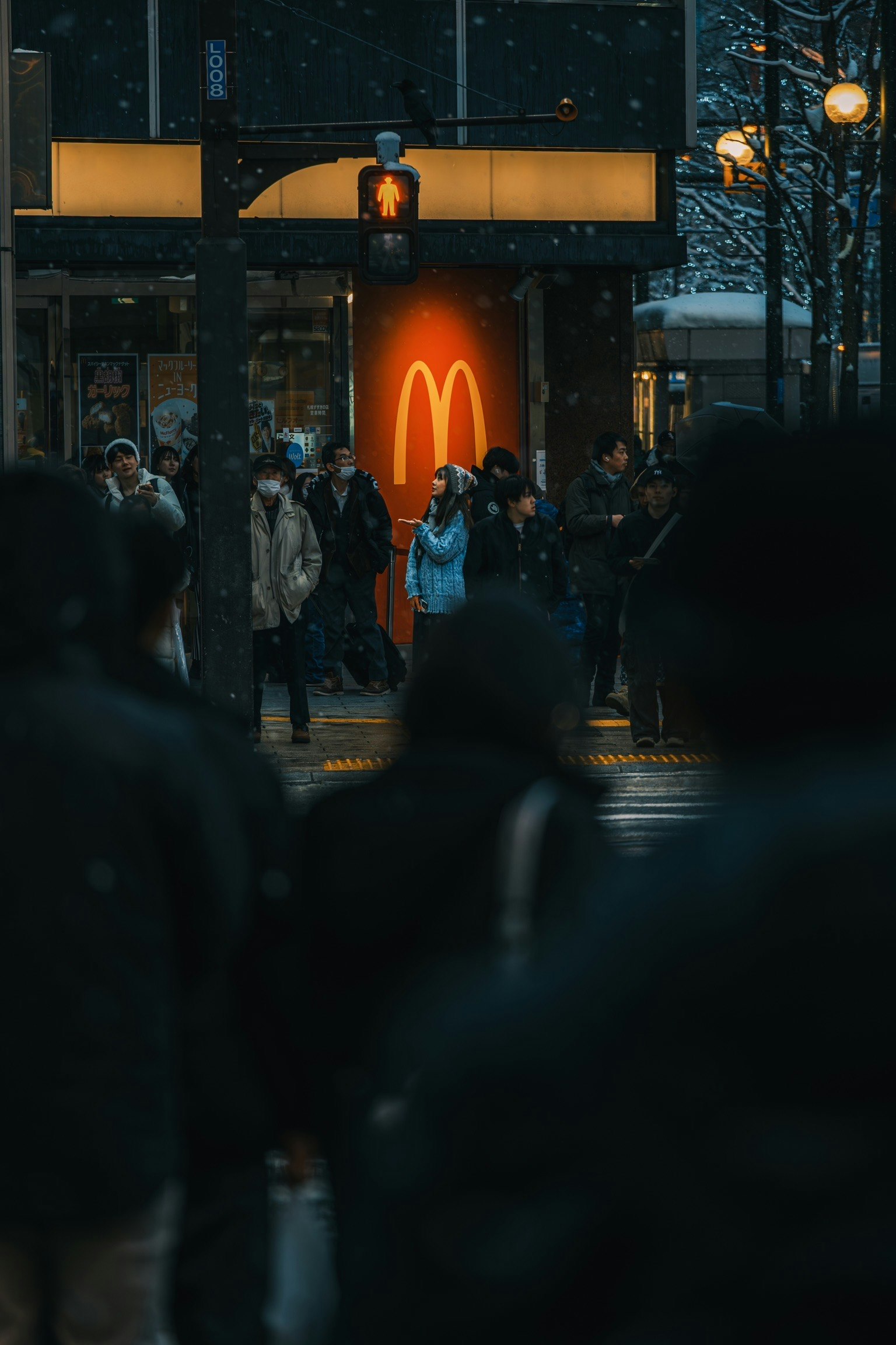 Scena urbana con persone che attraversano la strada e il logo di McDonald's sullo sfondo