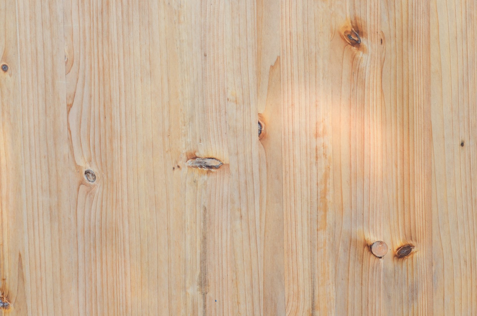 Superficie de madera clara con textura y nudos visibles
