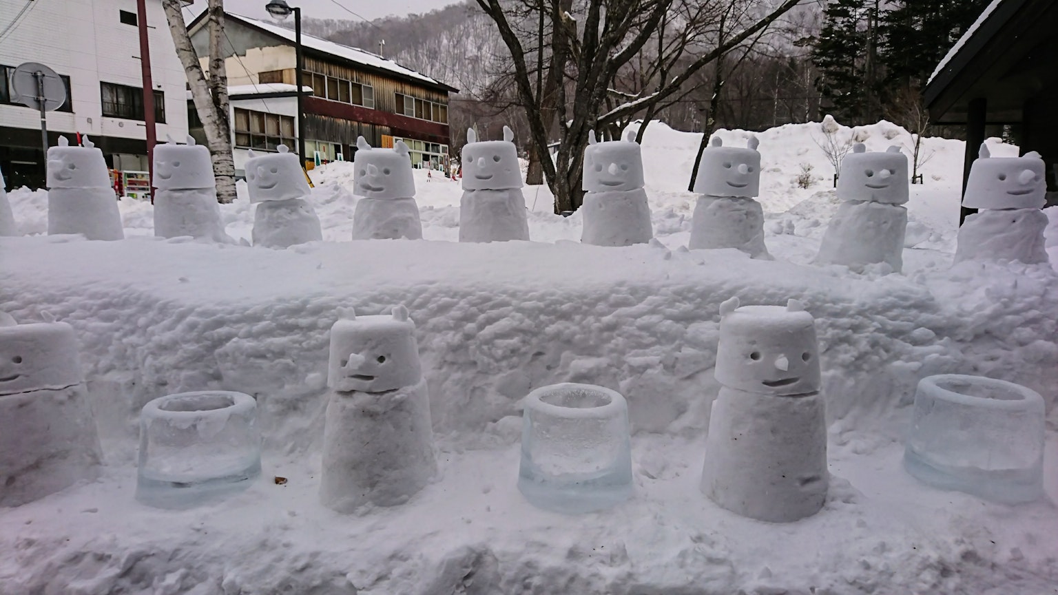 雪地中类似雪人的雪雕和冰制物体