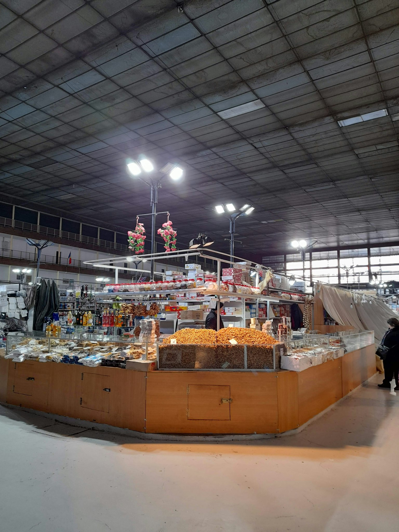 Escena de mercado interior con mostrador de madera exhibiendo varios productos y buena iluminación