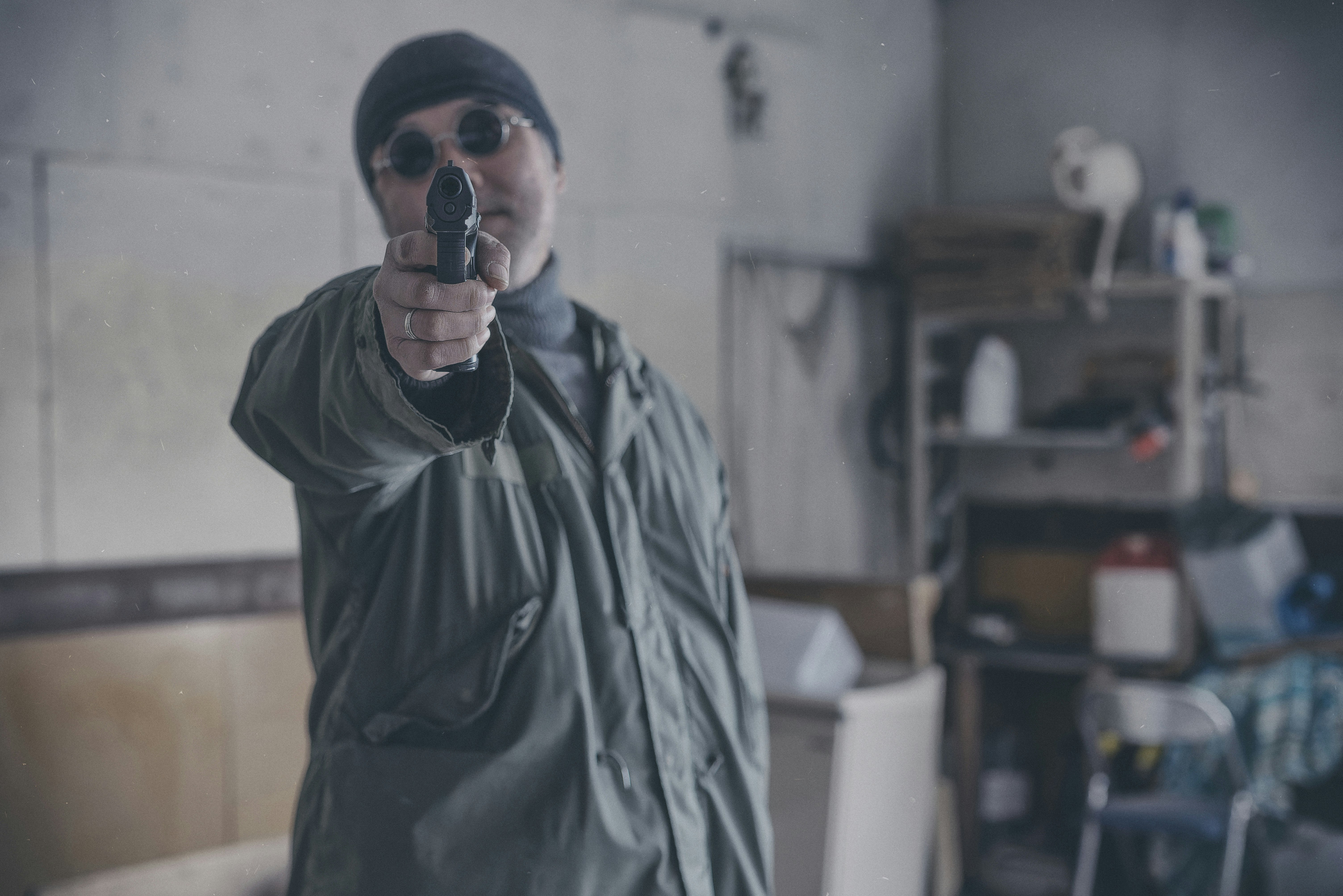 A sanitation worker wearing a protective mask holding cleaning tools