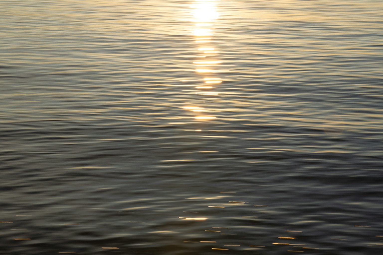 Superficie del mare calma che riflette la luce del sole creando un'atmosfera serena