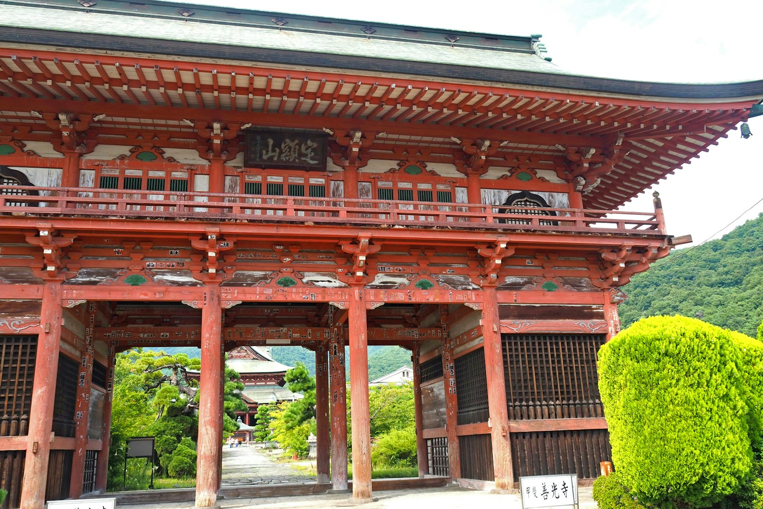 红色大门与郁郁葱葱的绿植在寺庙入口