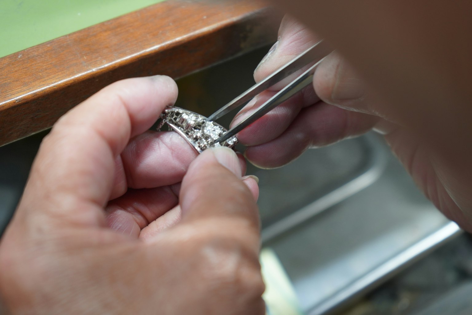 Mano de artesano sosteniendo un anillo detallado