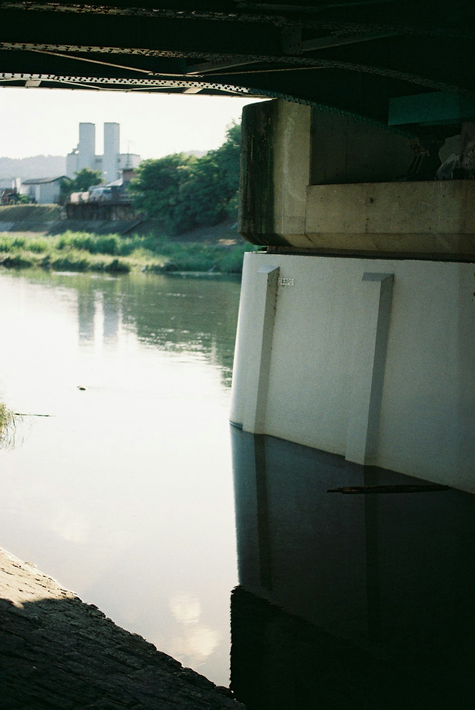 Tranquil river view from under a bridge with reflections