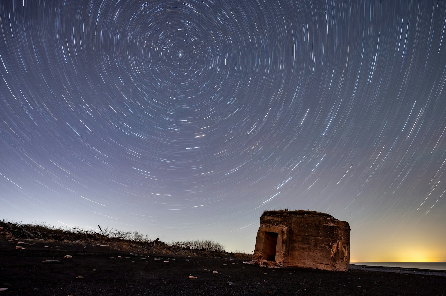 Ruined building under a starry sky with star trails