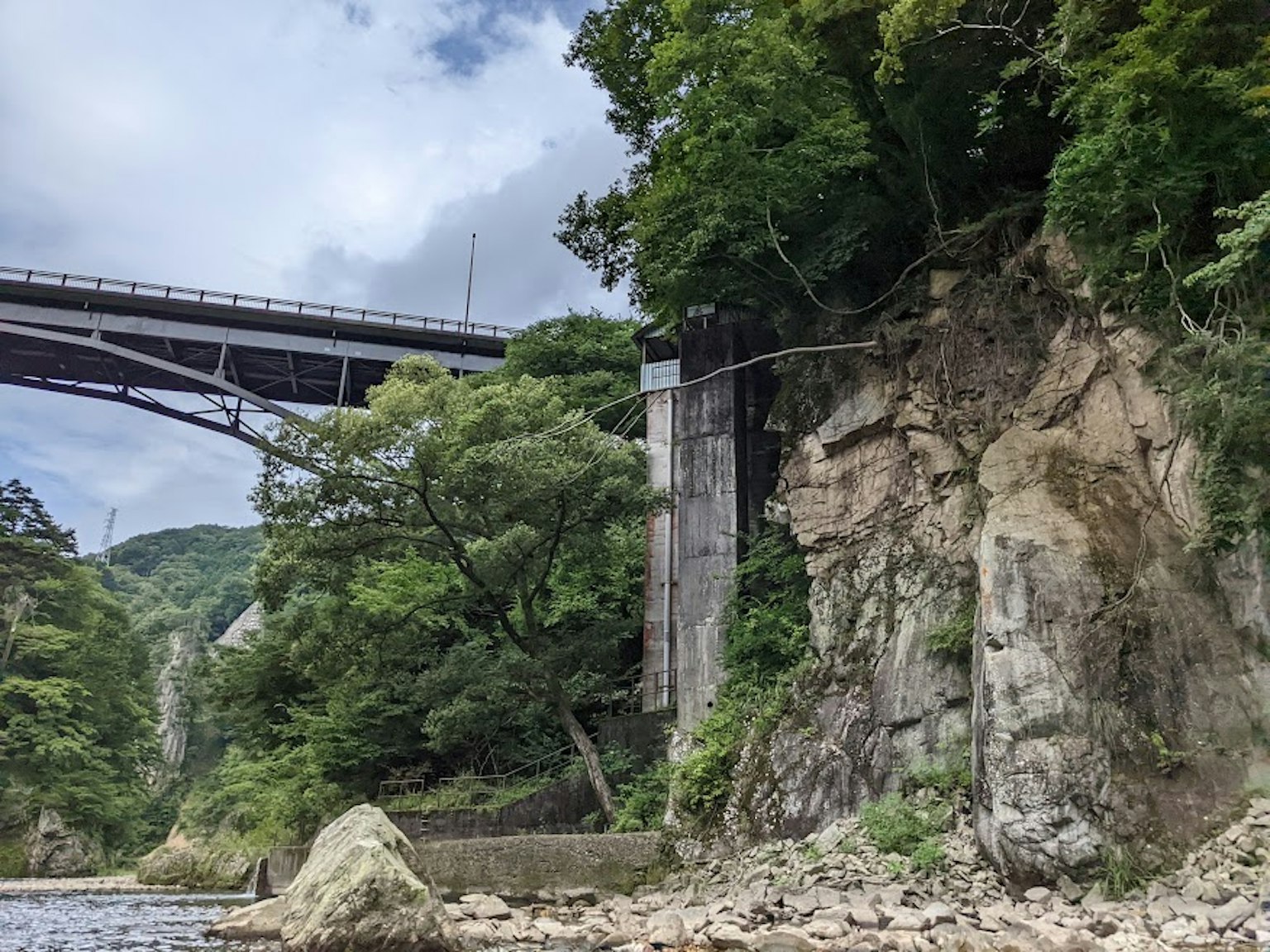 河流上的橋樑與岩石懸崖及茂密綠樹的風景