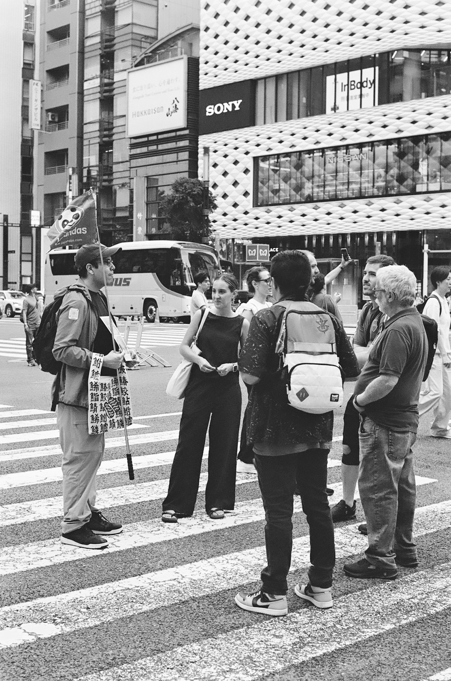 Black and white photo of people gathered at a crosswalk