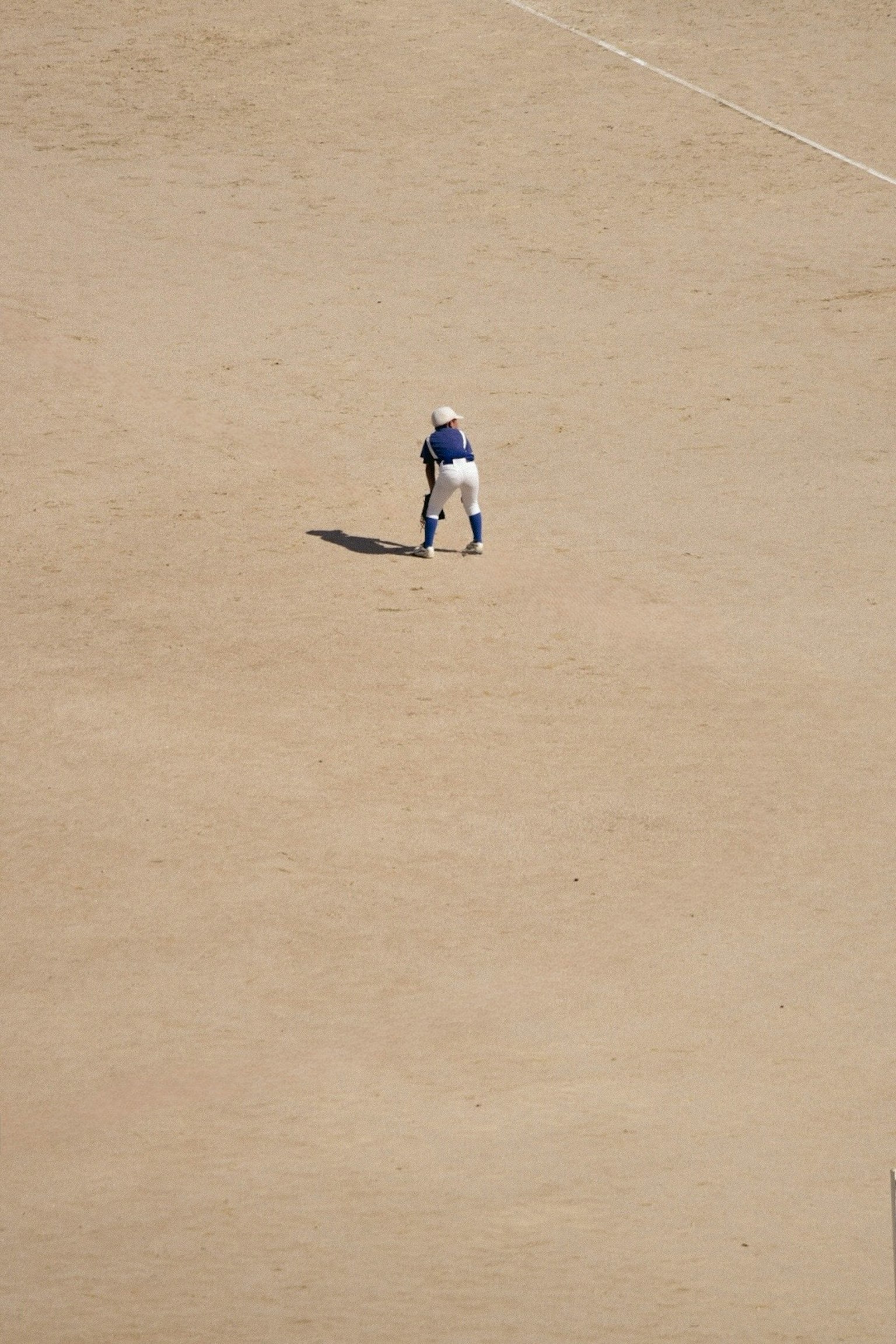 野球場の砂地に立つ選手の上からの視点