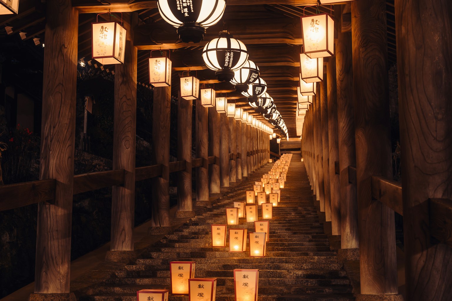 沿着木质人行道排列的灯笼和灯光的场景