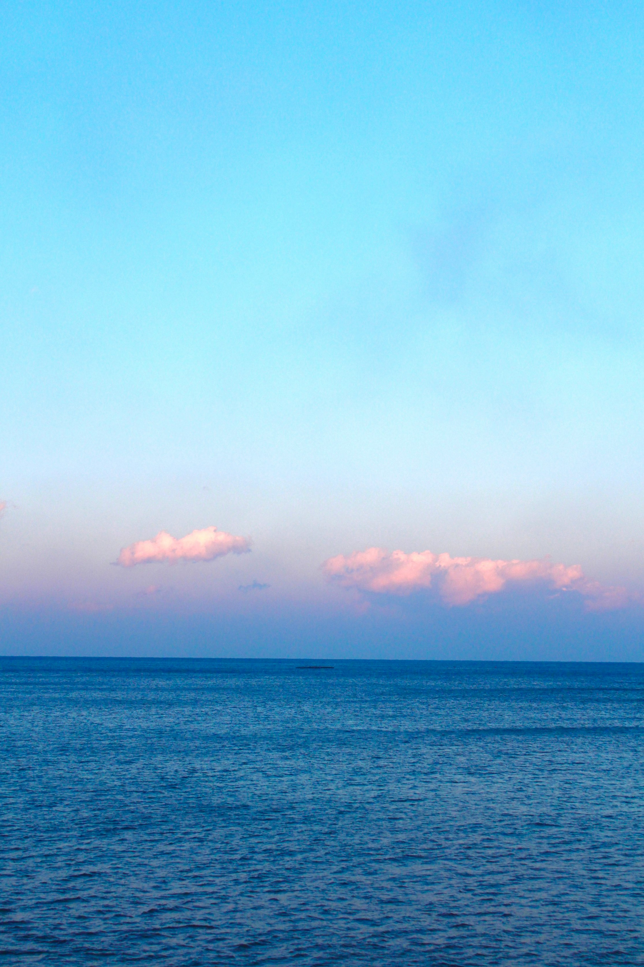 水平線に広がる青い海と夕焼けの雲