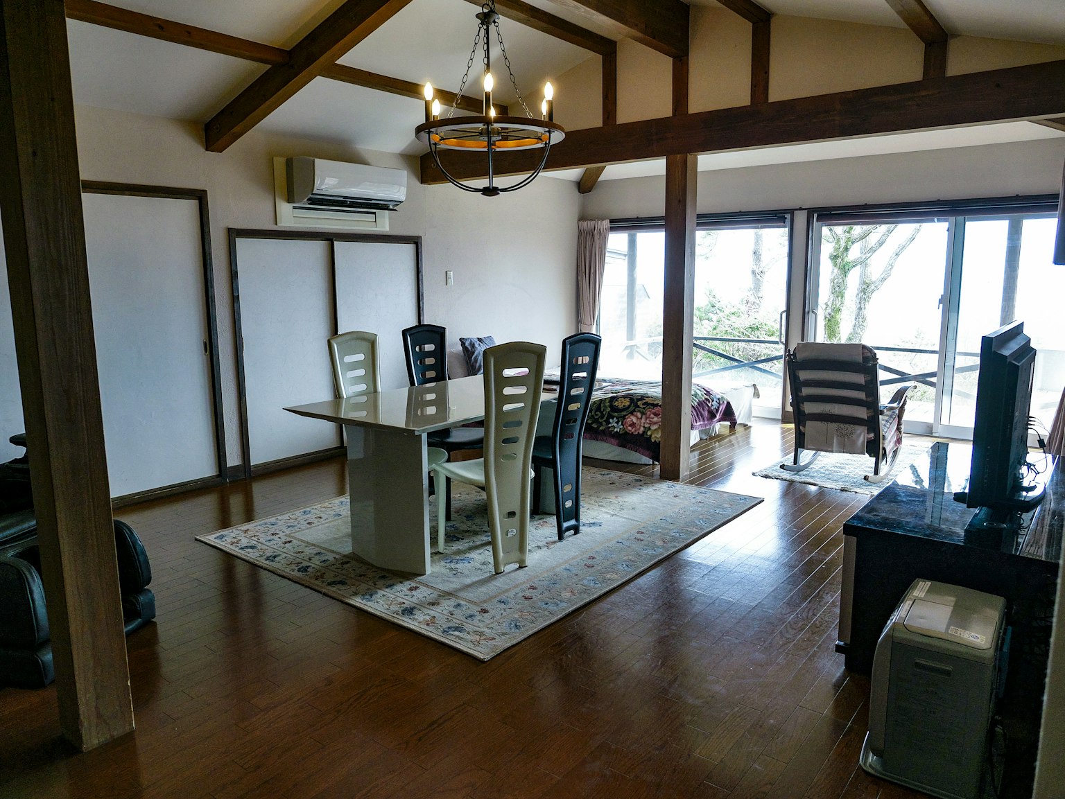Bright living room featuring a dining table and chairs with large windows allowing natural light