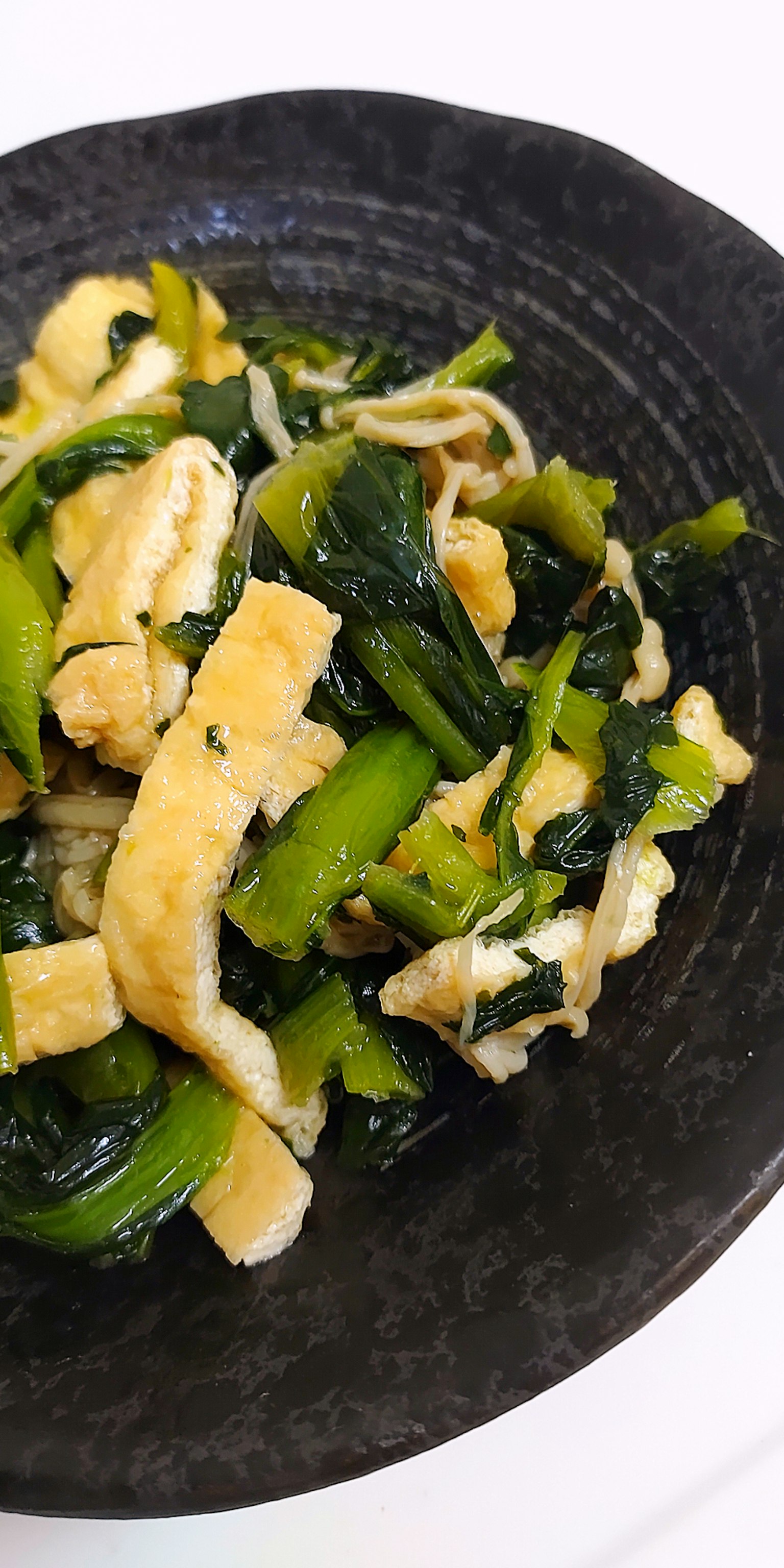 Stir-fried vegetables and eggs in a black bowl