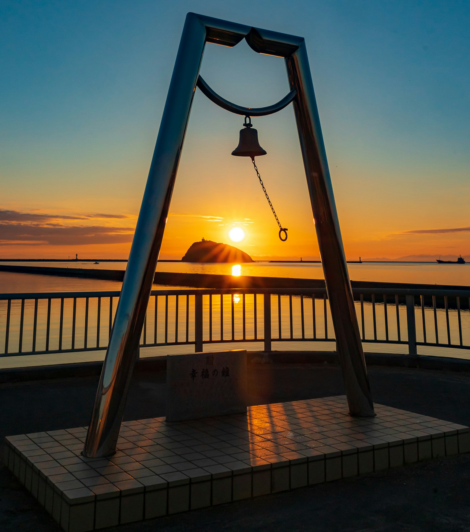 夕阳映照下的钟形纪念碑与大海的美丽景色