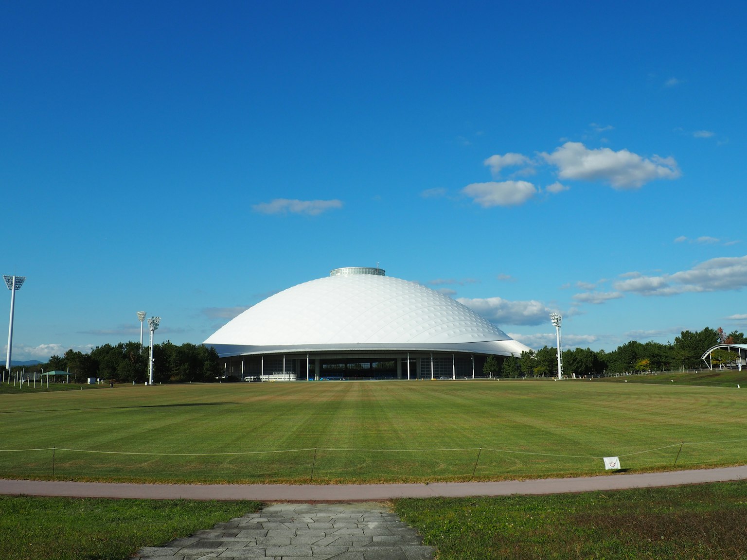 藍天下的大型圓頂建築和廣闊的綠色草坪