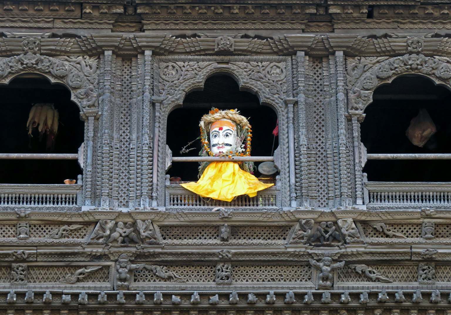 Finestra in legno decorativa con figura divina e tessuto giallo