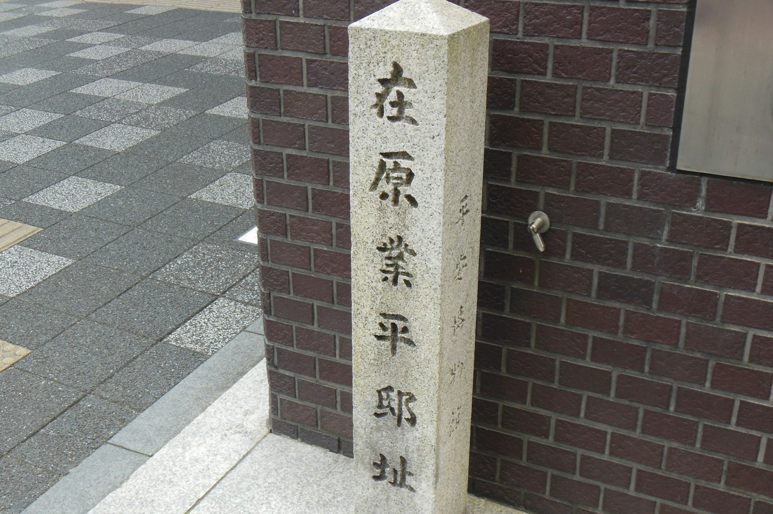 Stone sign displaying characters in the streets of Hirano