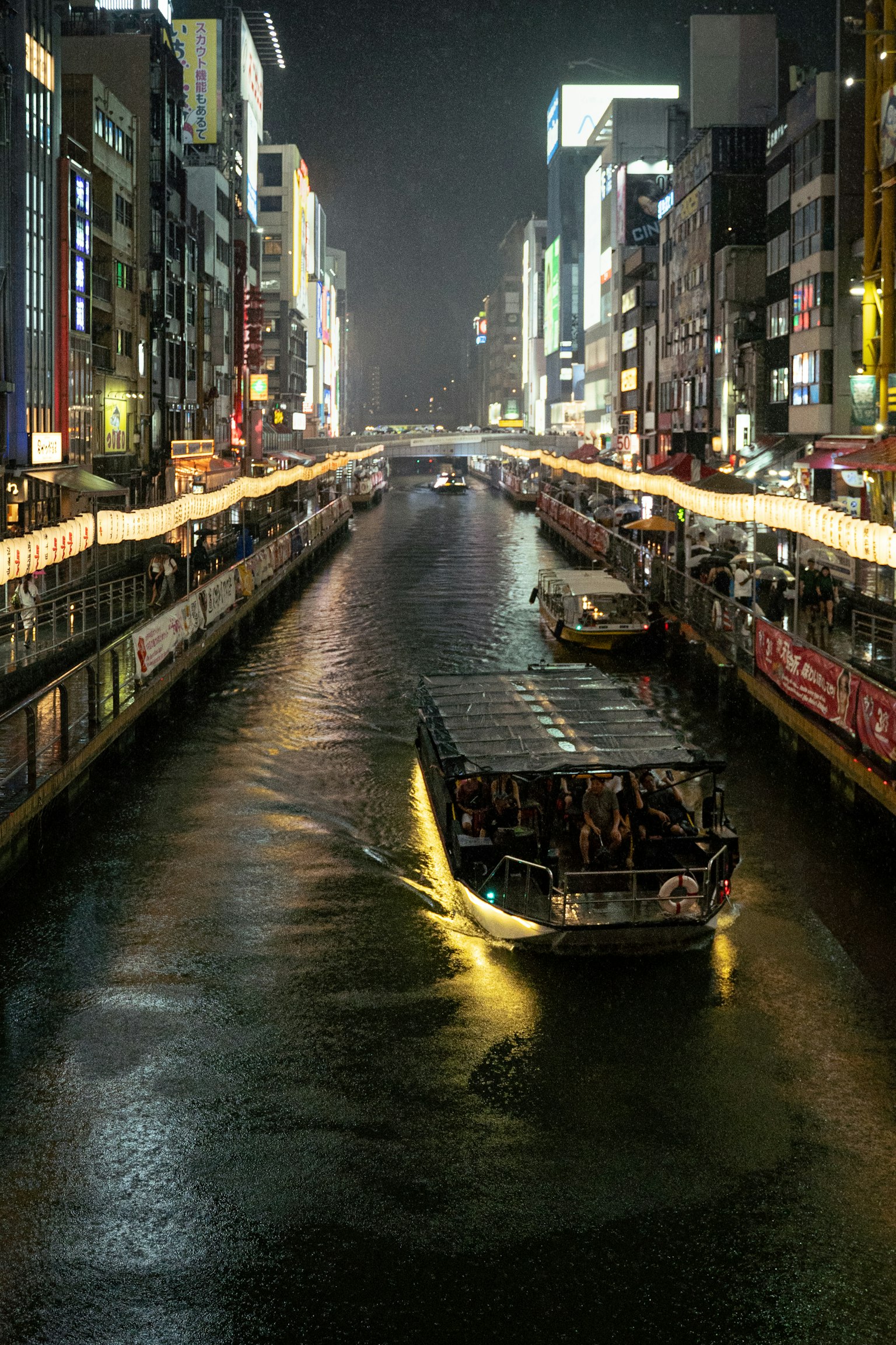 夜间河流上的游船与明亮的城市灯光