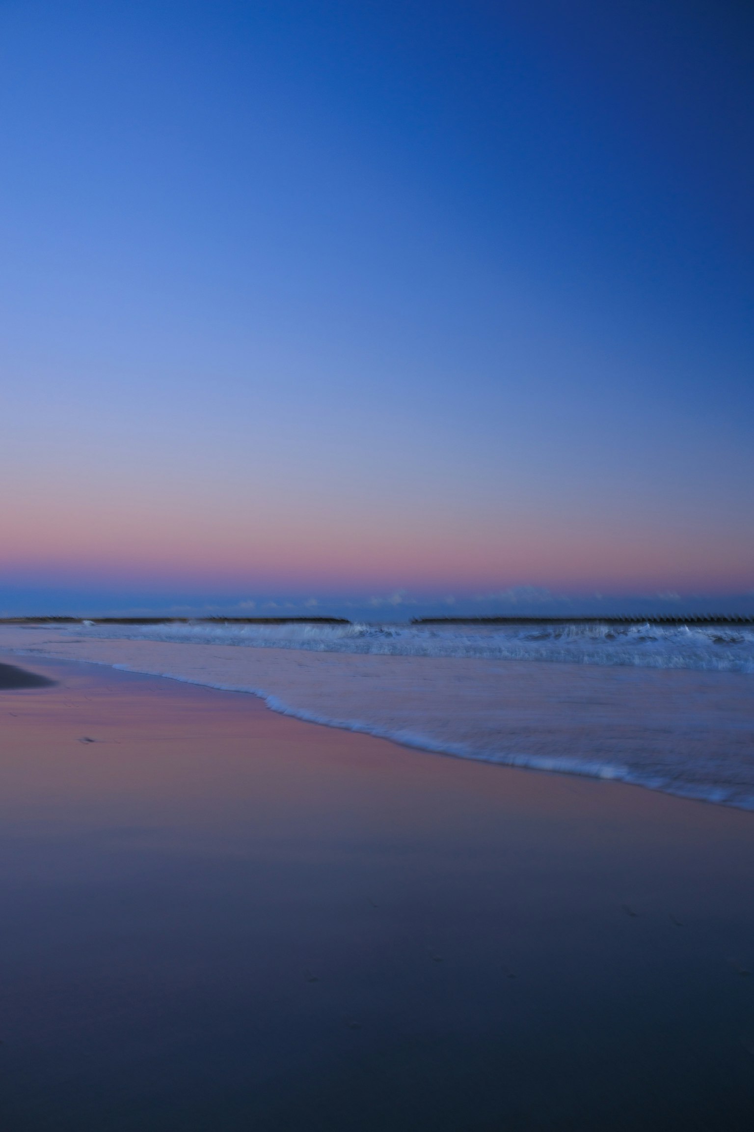 Escena de playa serena con un cielo degradado y olas suaves