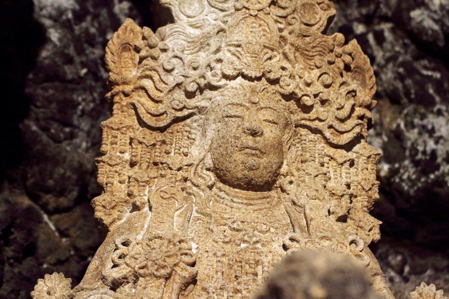 Stone sculpture of a deity visible in a cave
