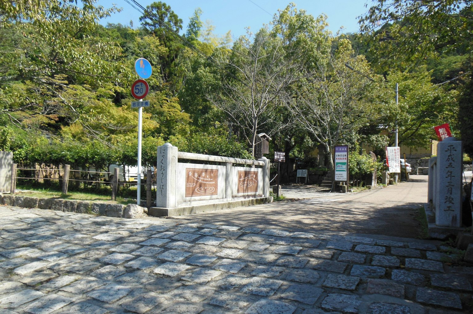 公園入口，有卵石小路和茂密的綠色樹木