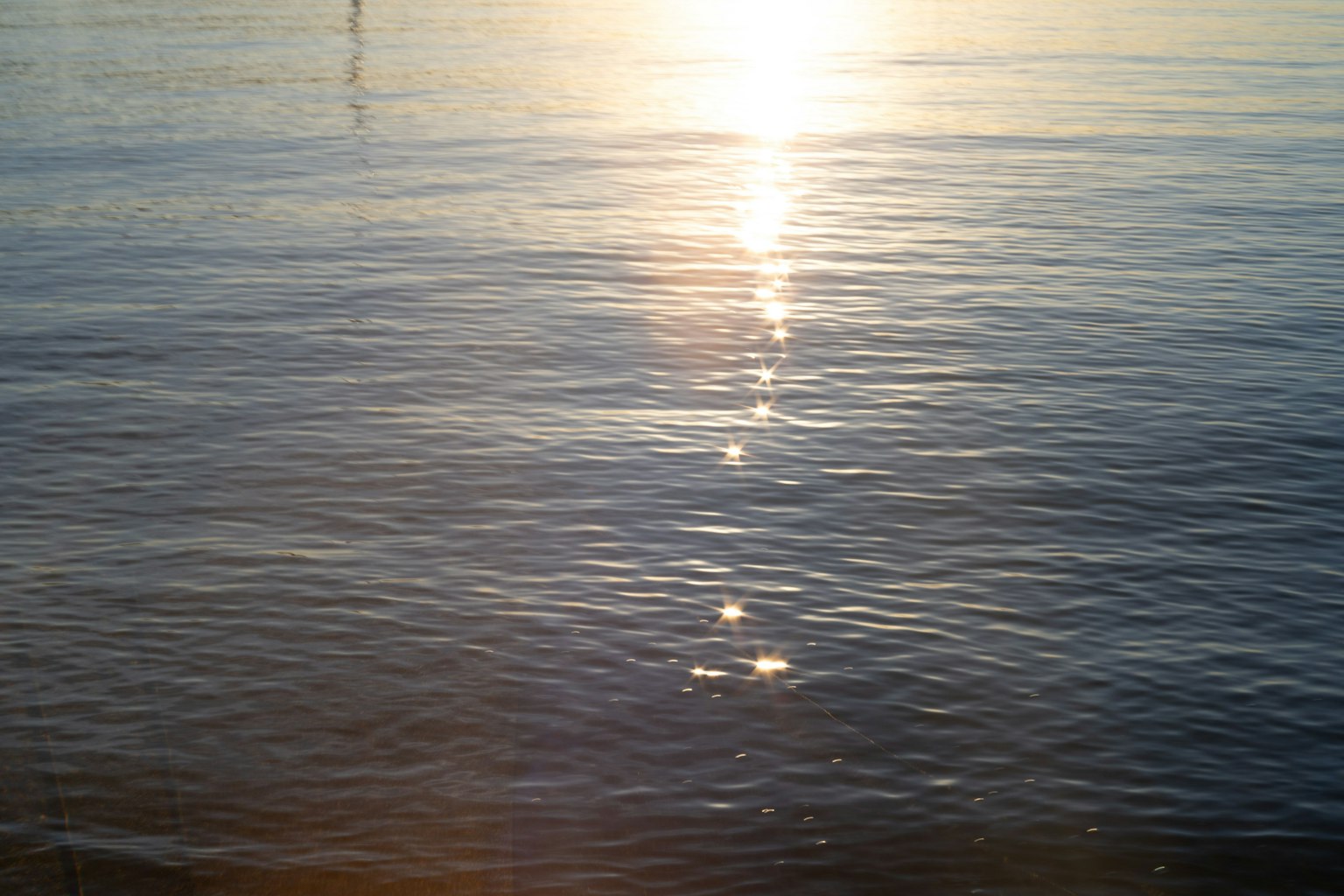 Superficie d'acqua calma che riflette la luce del sole