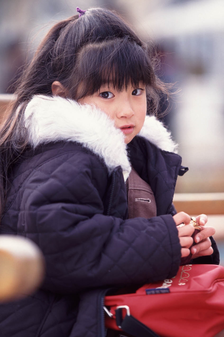 niña con abrigo de invierno sujetando la mano en la calle
