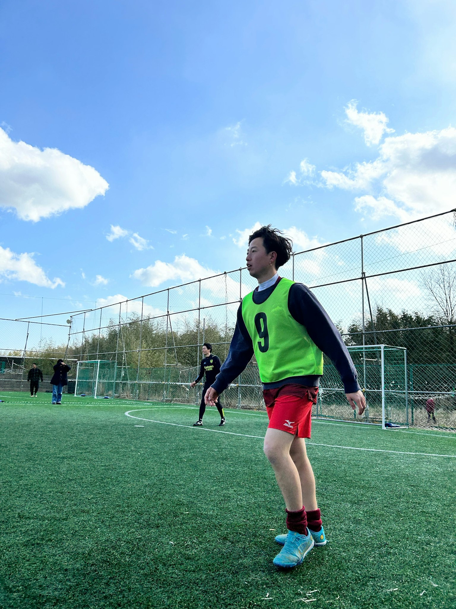 초록색 조끼를 입고 있는 축구 선수가 필드에서 훈련 중