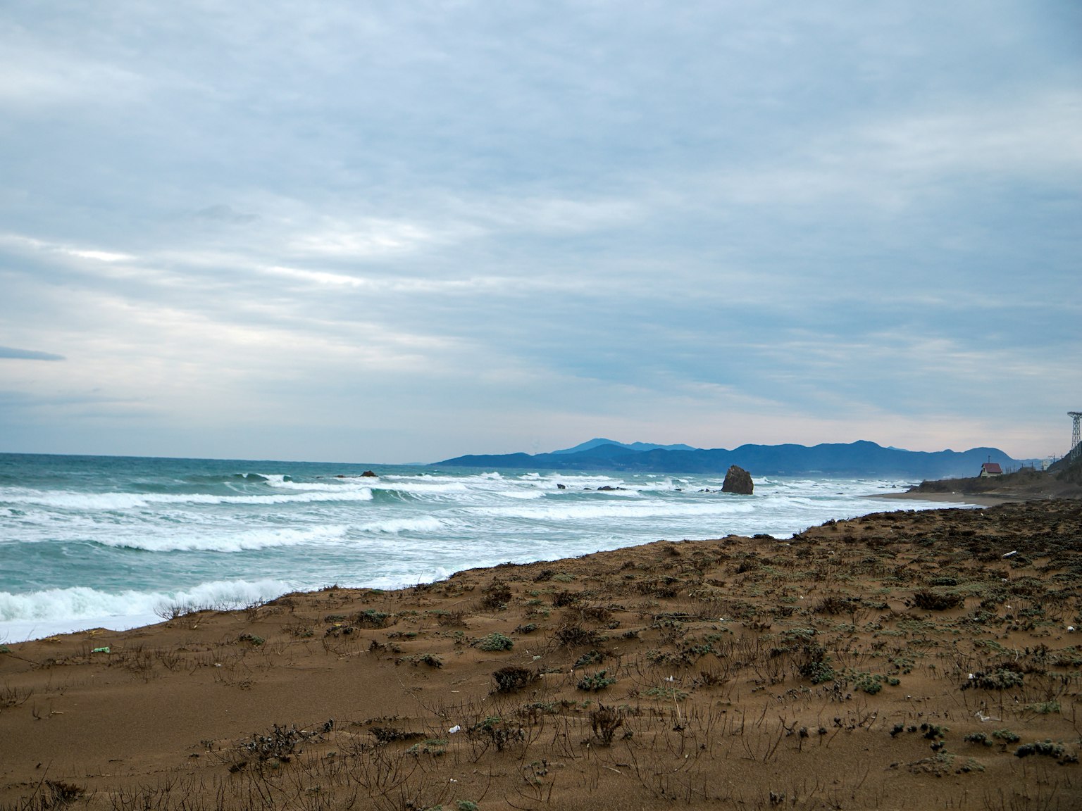 海岸風景，波浪和沙灘在陰雲下