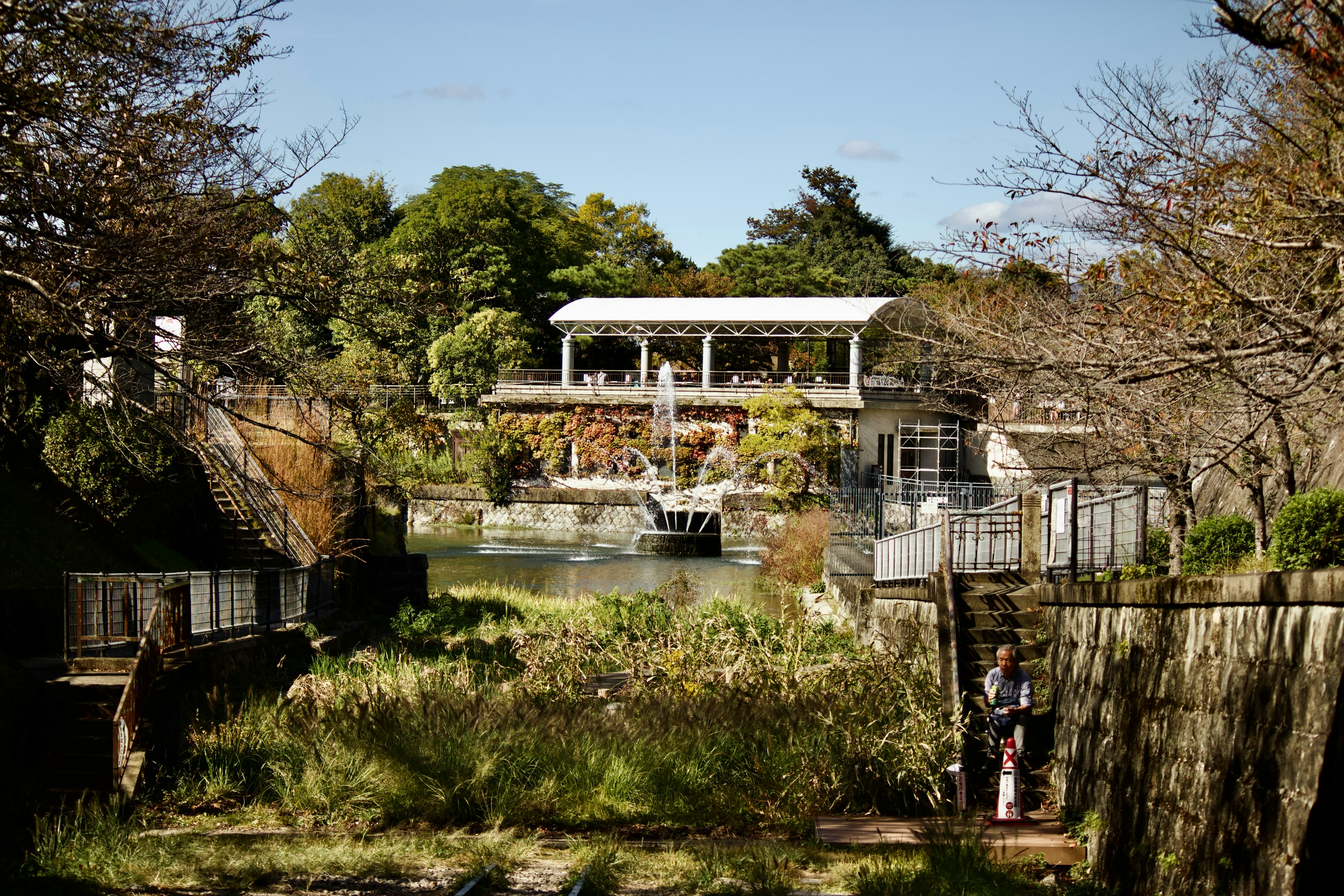 fountain and small bridge in a riverside garden